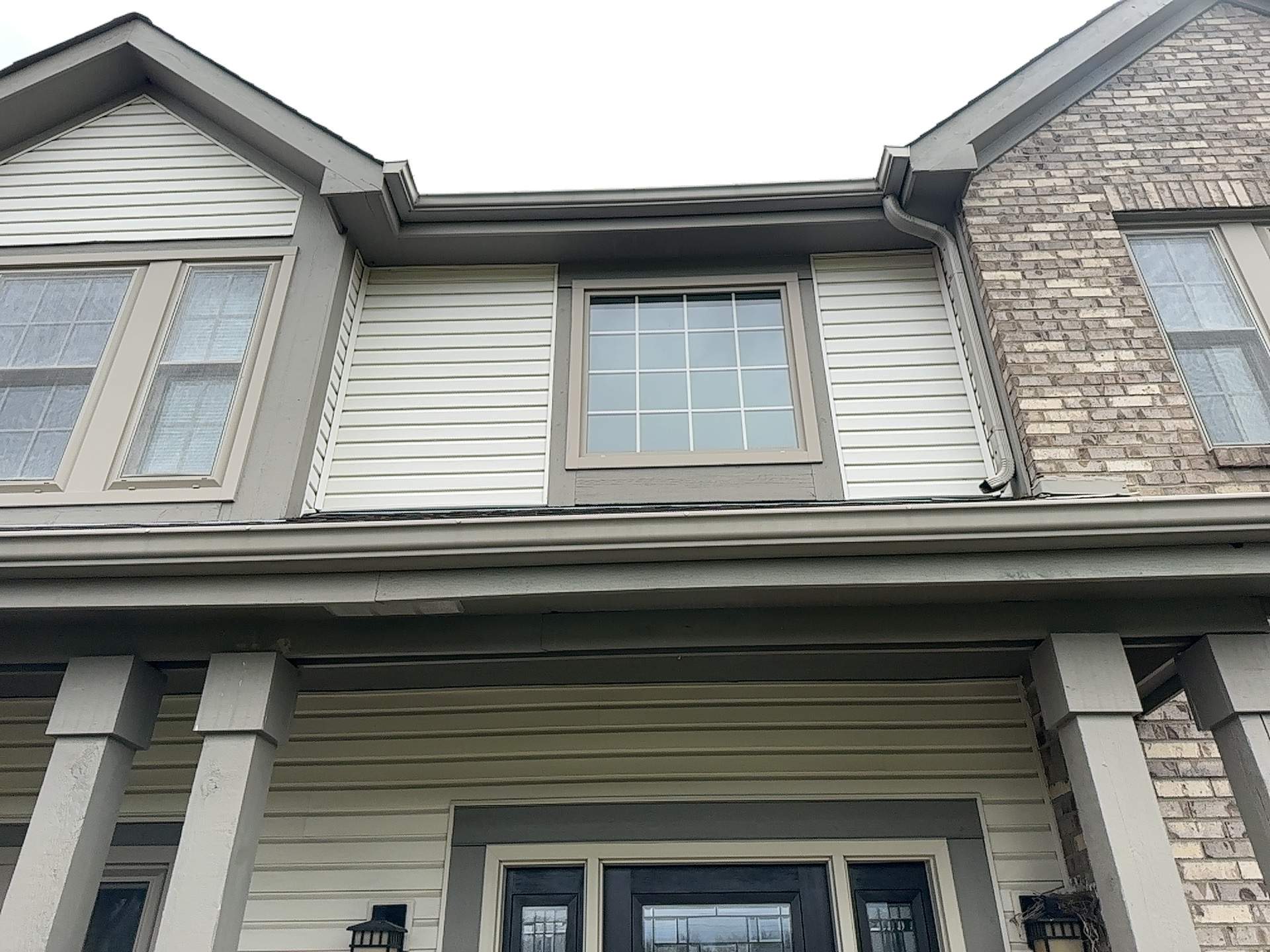 Upper front of the home before renovation, showing the original roof and light siding
