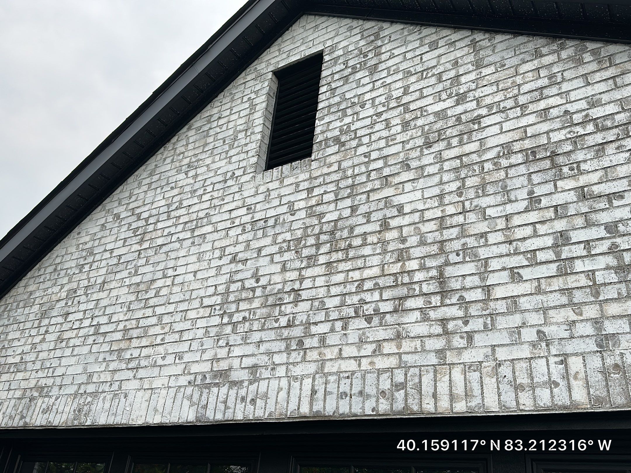 Side of the home after renovation, with dark siding and a dark roofline