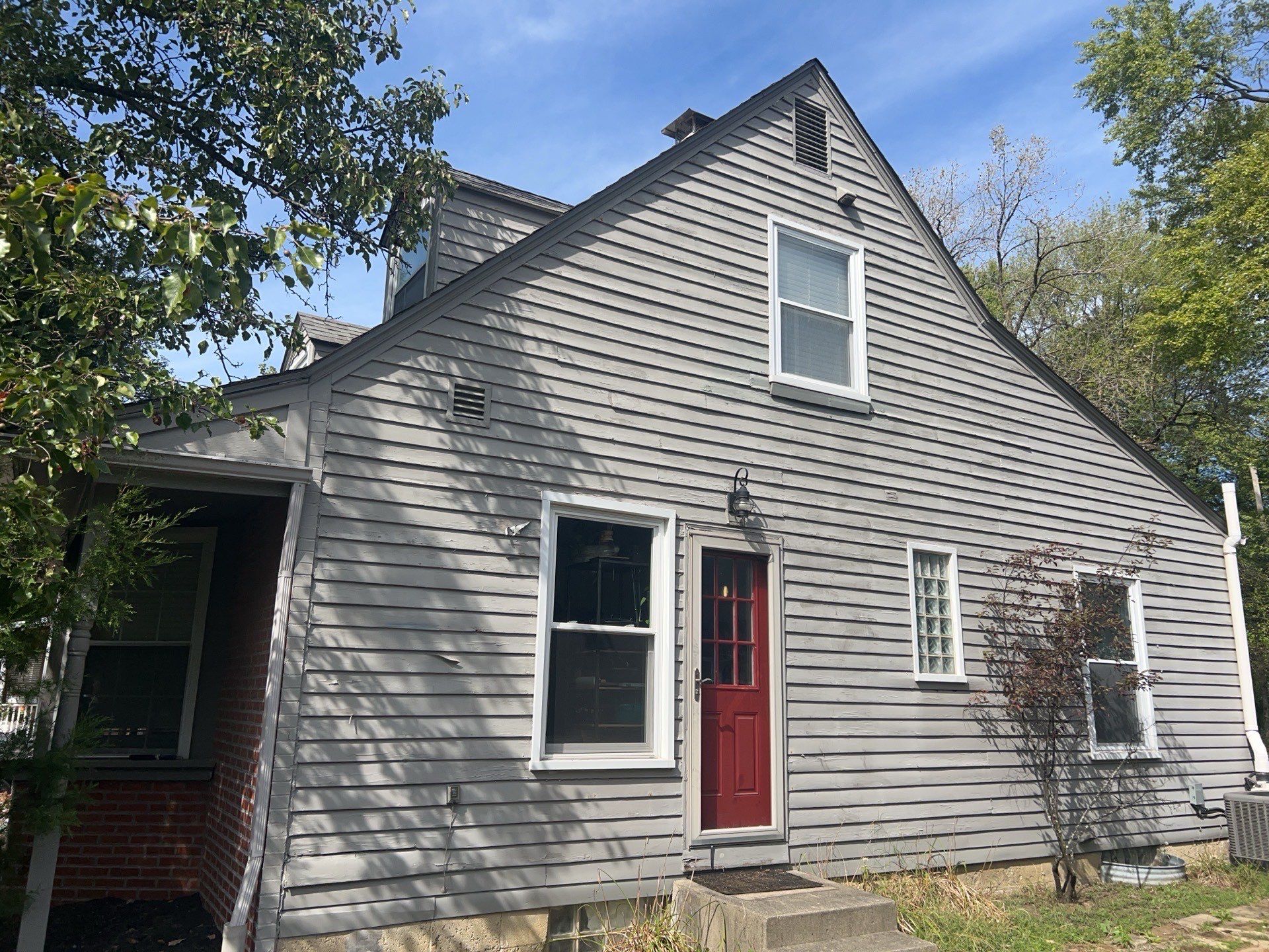 Side of the home before restoration, showing the older gray-green siding