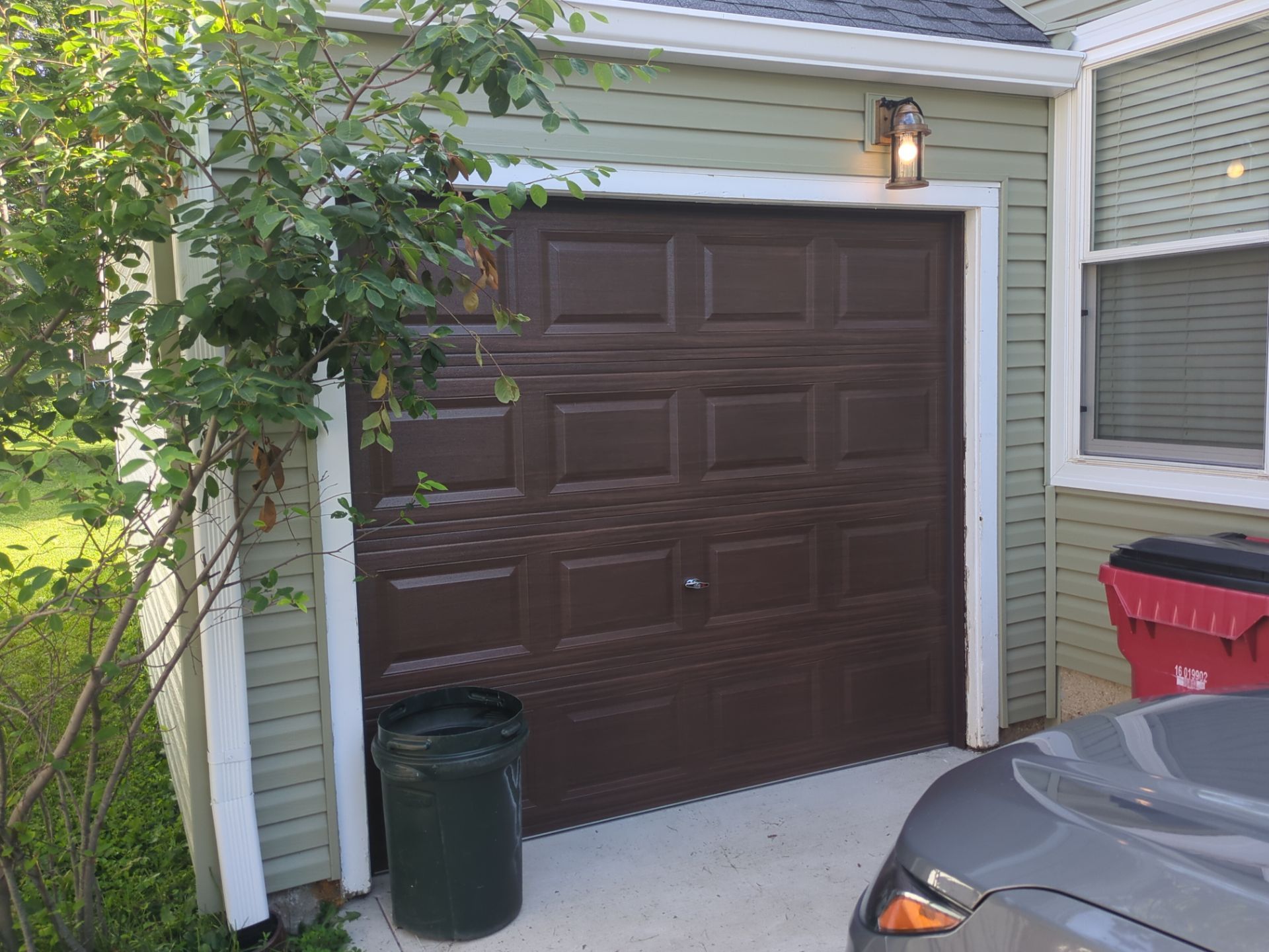 Close view of the dark garage door and new siding after the exterior restoration
