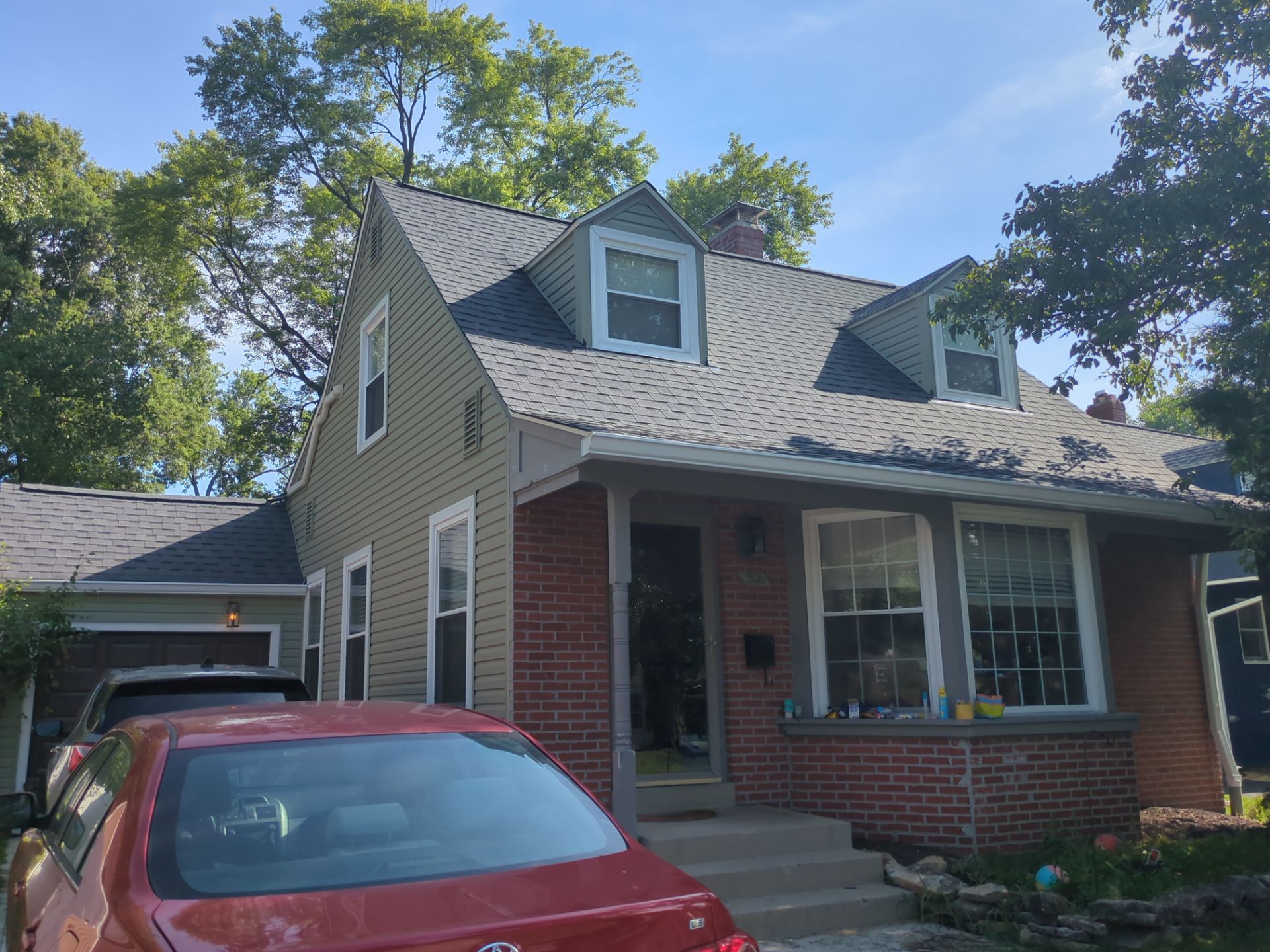 Brick-front Worthington home with dormers after roof and siding restoration