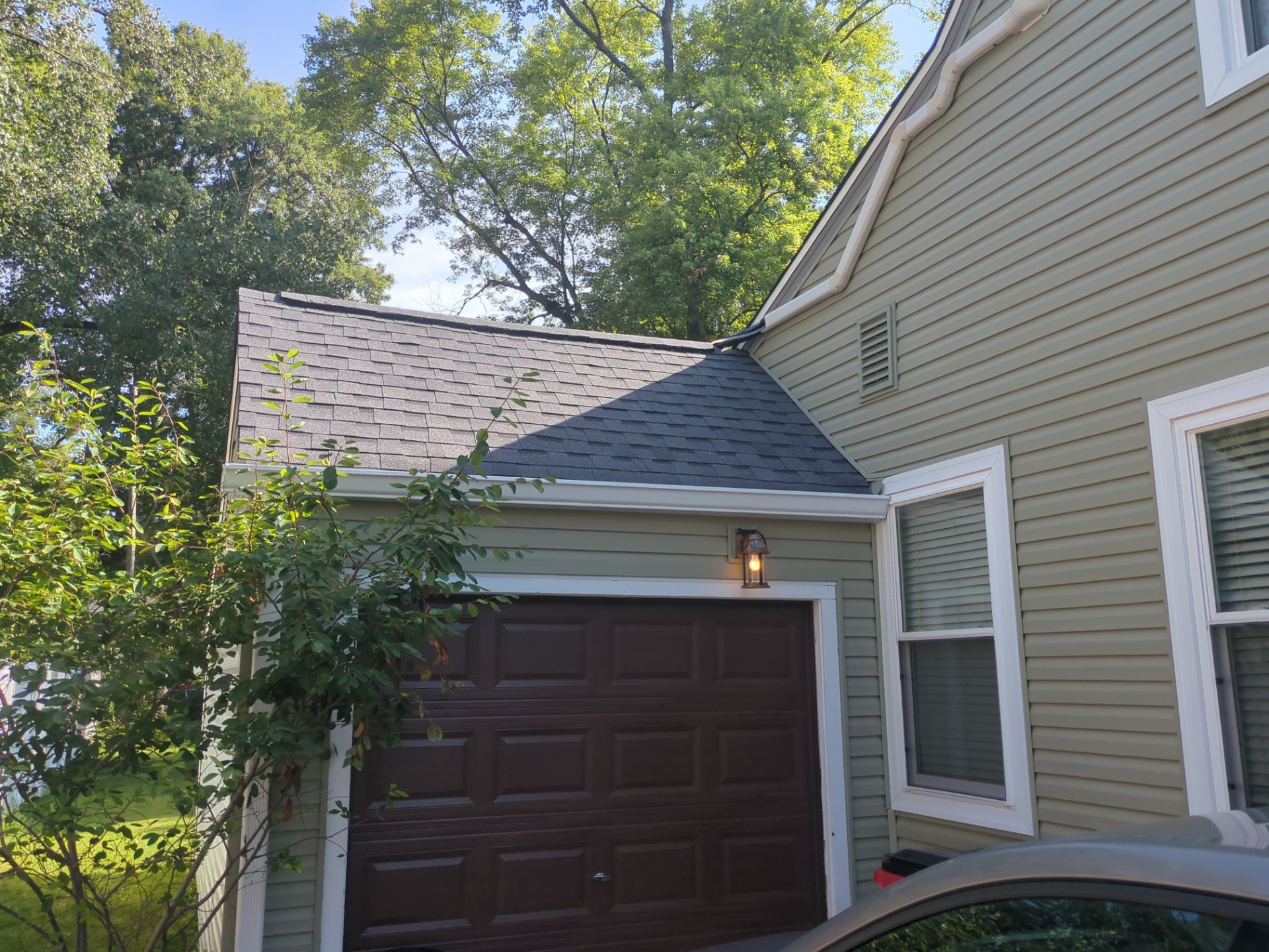Worthington home after roof and siding restoration, with darker siding and a dark garage door
