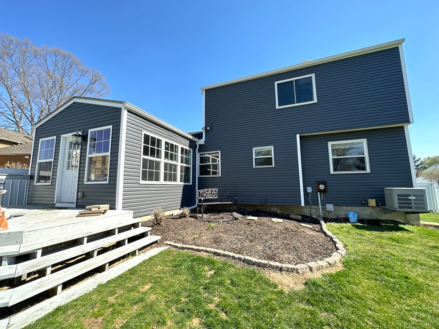 Rear of the home after new roofing and dark blue-charcoal siding were installed