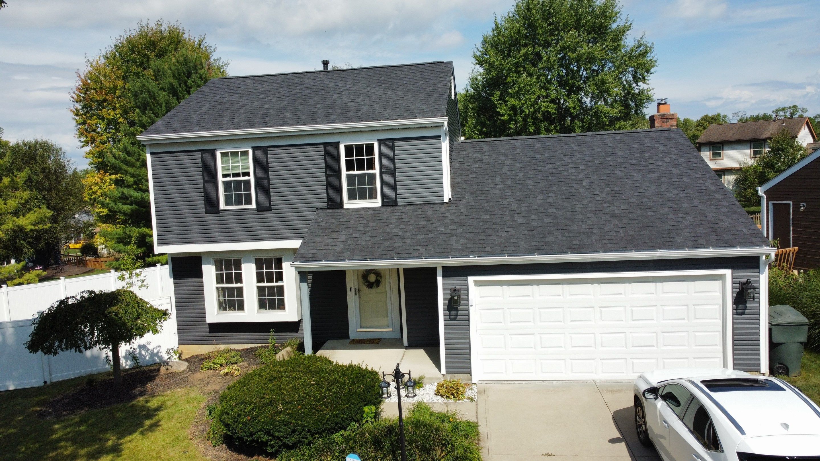 Two-story Gahanna home after roofing and siding transformation with dark siding, white trim and new roof