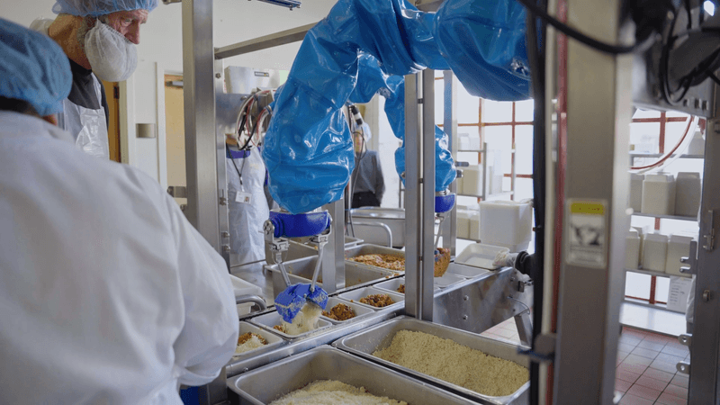 Chef robot picking and placing ingredients into compartmentalized trays