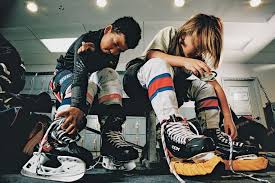 Young hockey players tying their skates in a locker room