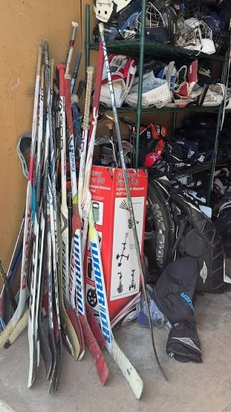 Collection of used hockey sticks and equipment ready for another player