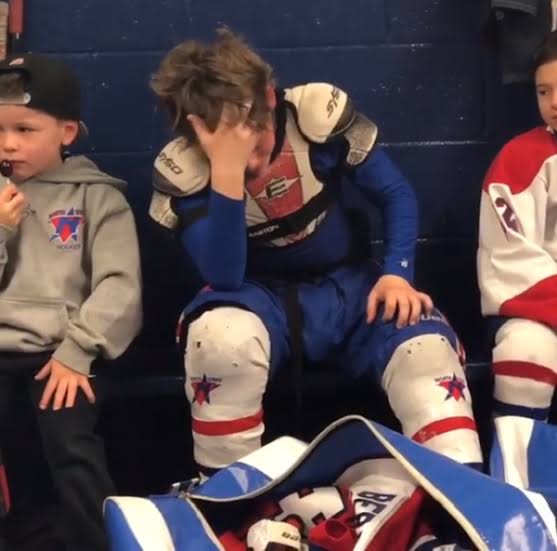 Young hockey player sitting with his head in his hand after a difficult moment