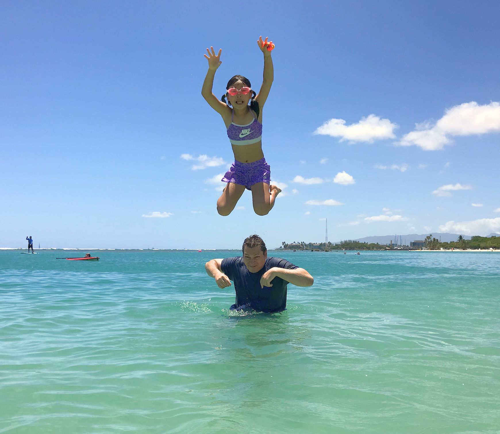 Child jumping in air over the ocean in Hawaii