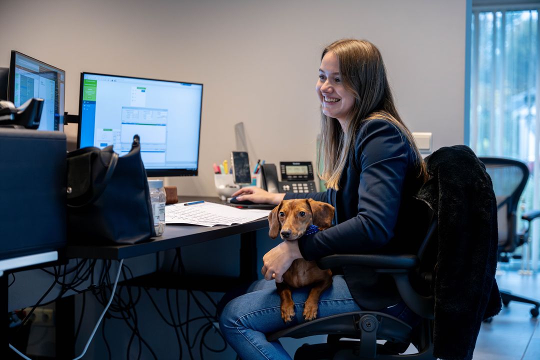 Collega werkt met haar hond op schoot — huisdieren zijn in samenspraak welkom