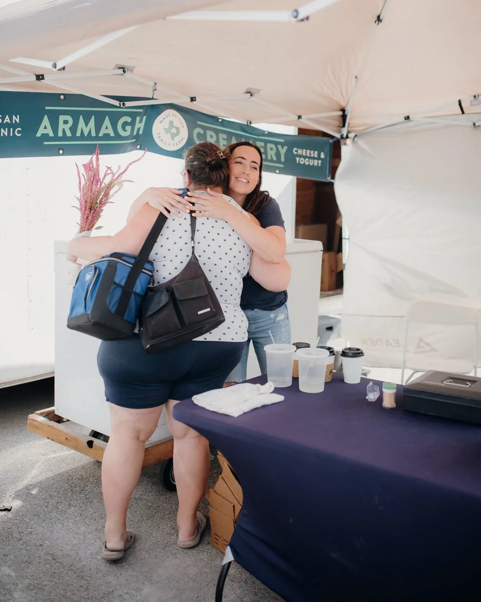 Katie hugging a member at the Armagh Creamery pickup booth
