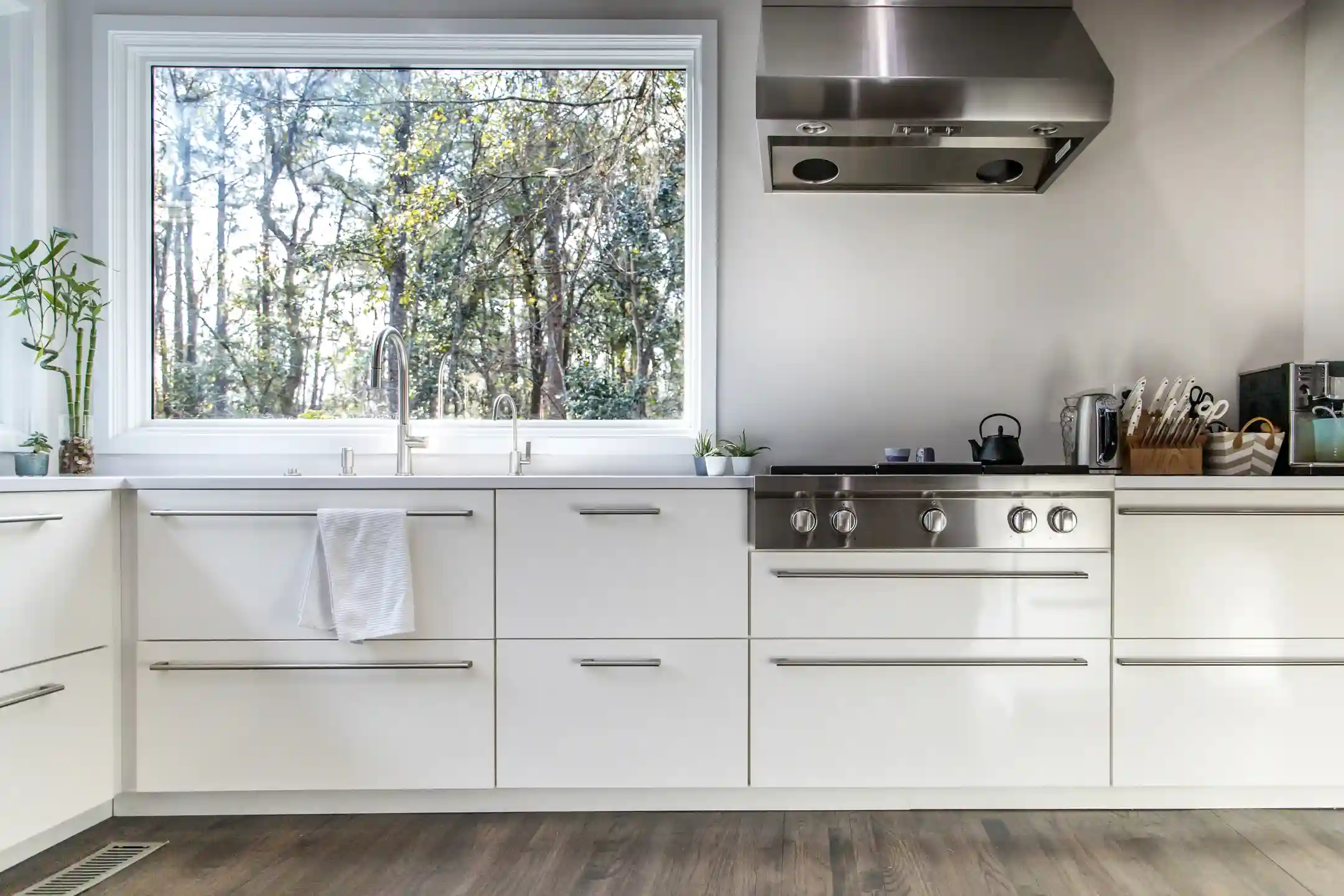 Modern kitchen with large window overlooking trees