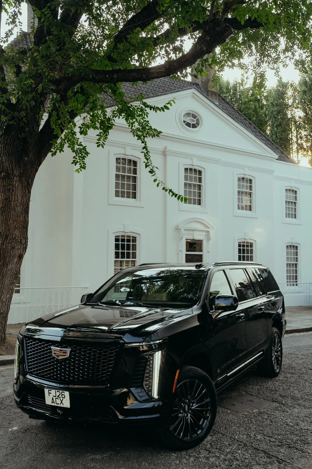 Black Veloria chauffeur SUV in front of a white building
