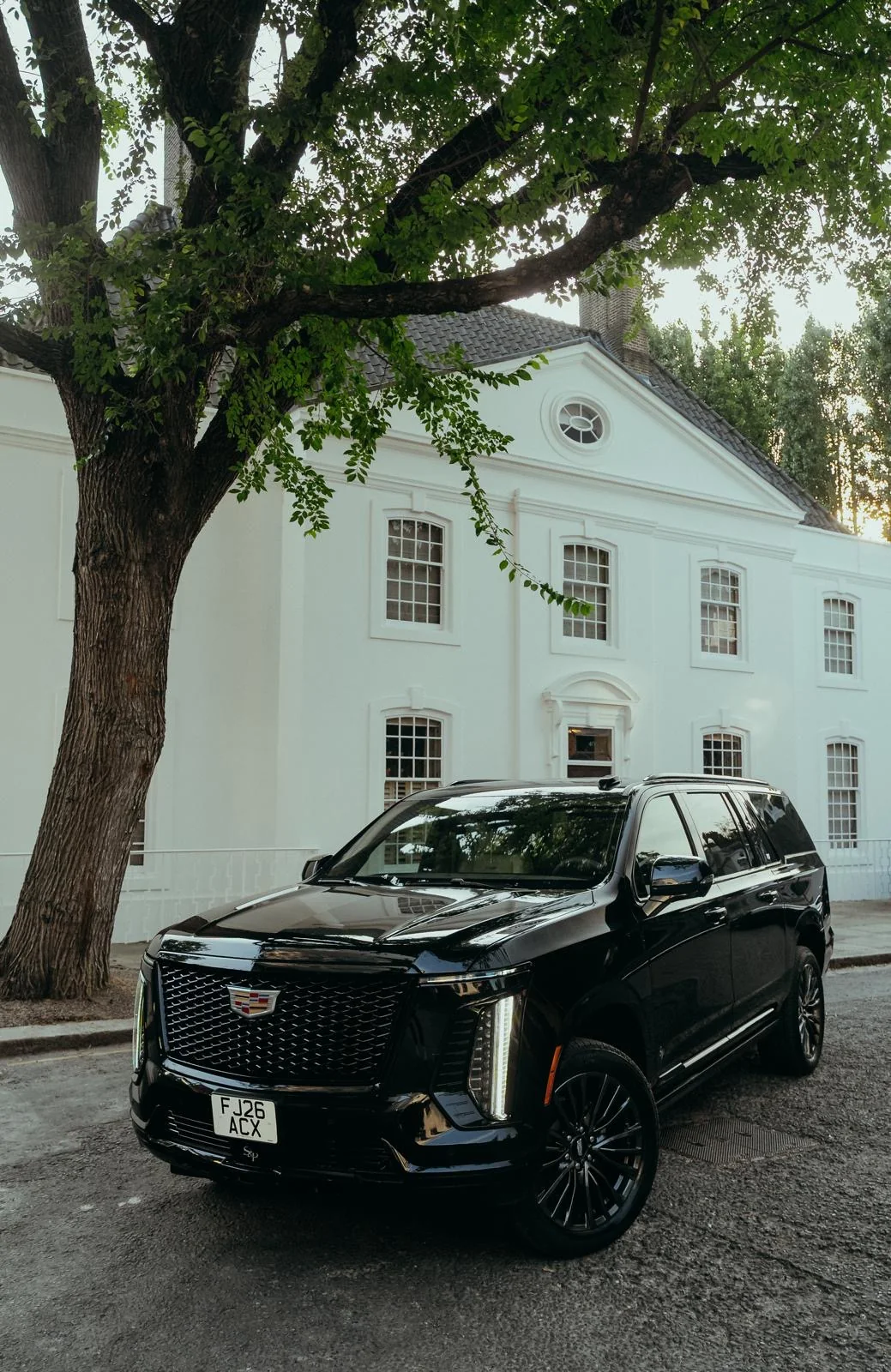 Black Veloria chauffeur vehicle outside a white building
