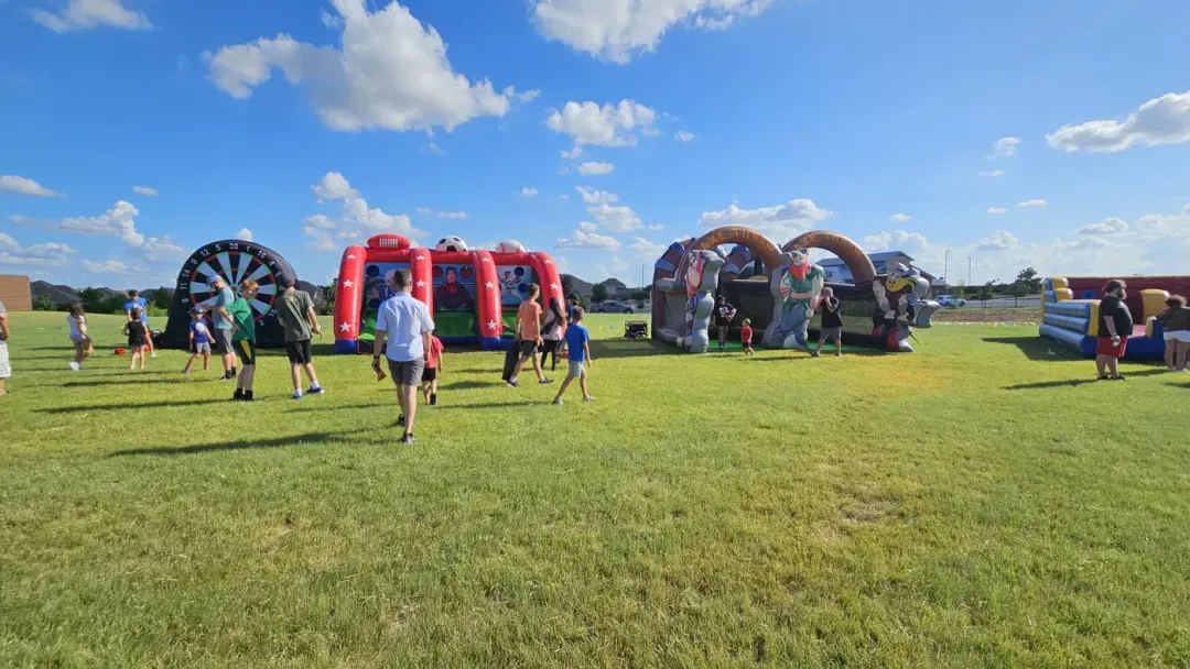 Families playing giant darts, sports challenges and axe throw together at a Freedom Fun community event