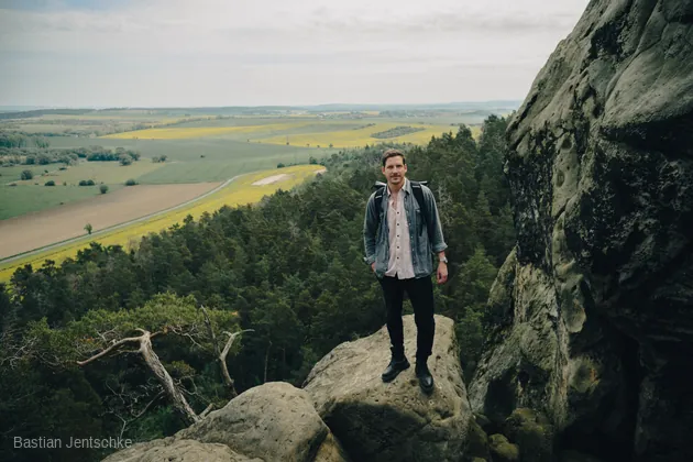 Jan Schmidt auf einem Felsen über der Landschaft