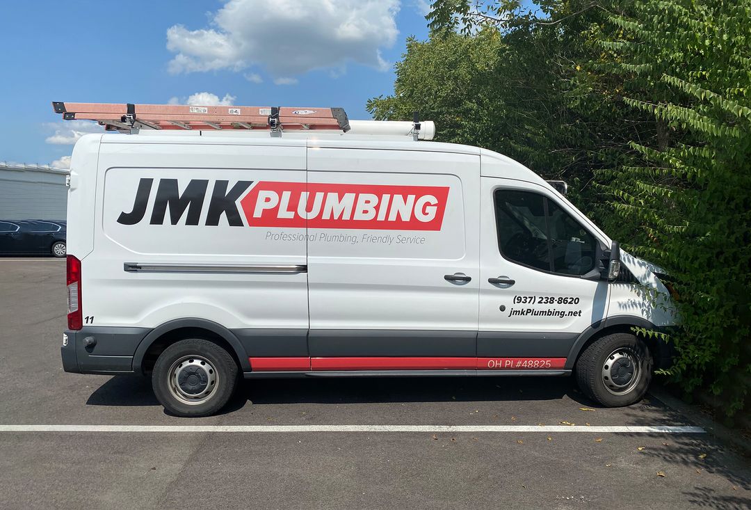 Before: white JMK Plumbing van