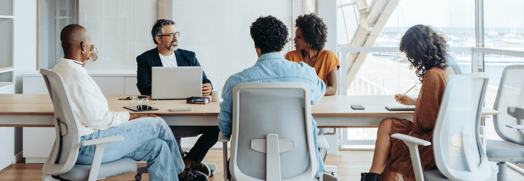 A leadership team in discussion around a conference table