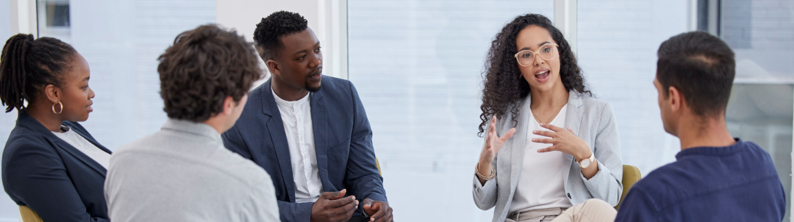 A team in a facilitated discussion, one member speaking while colleagues listen