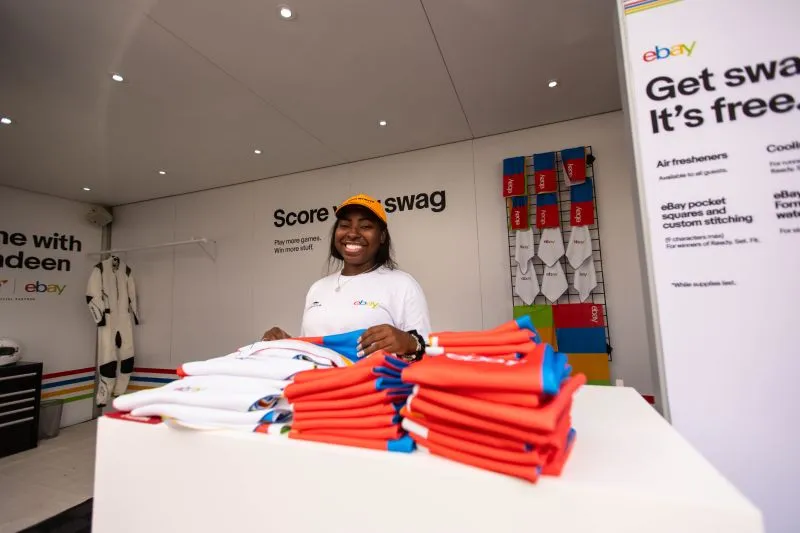 Cooling towels and pocket squares at the eBay giveaway counter, with a team member wearing the white eBay and Circuit of the Americas tee