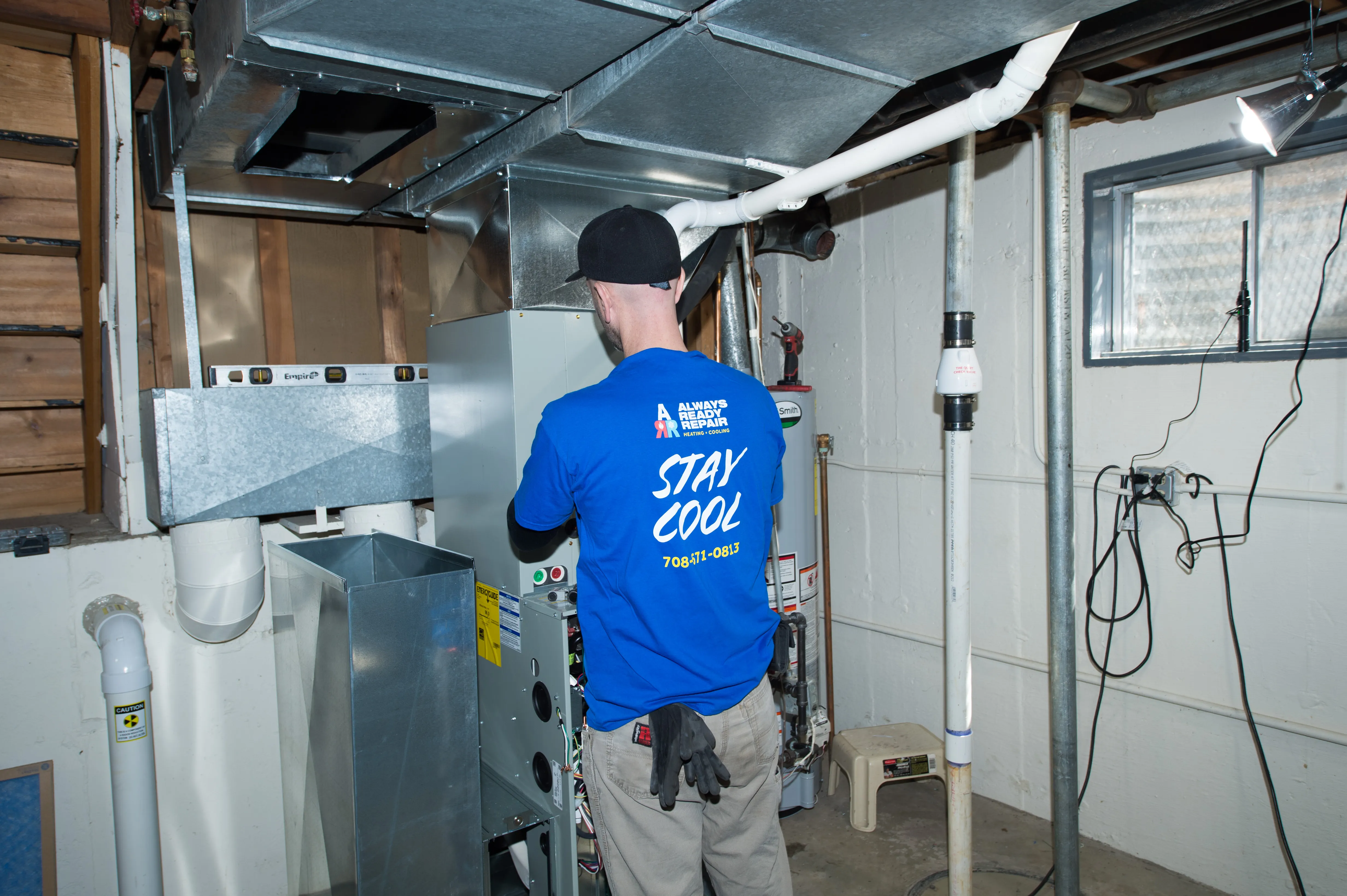 Technician testing controls at an open service panel