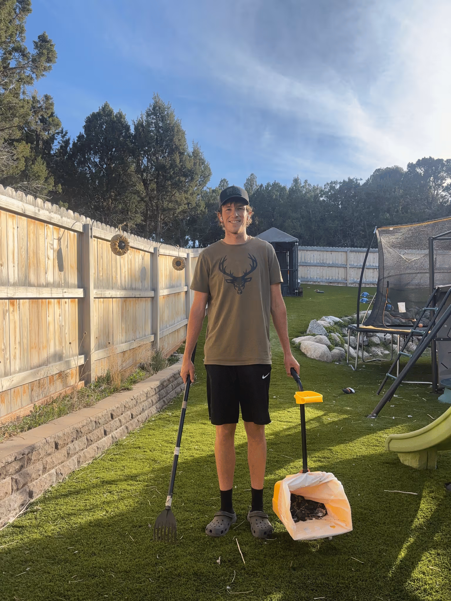 Spencer Scoops technician scooping dog waste in a residential backyard in Herriman, Utah