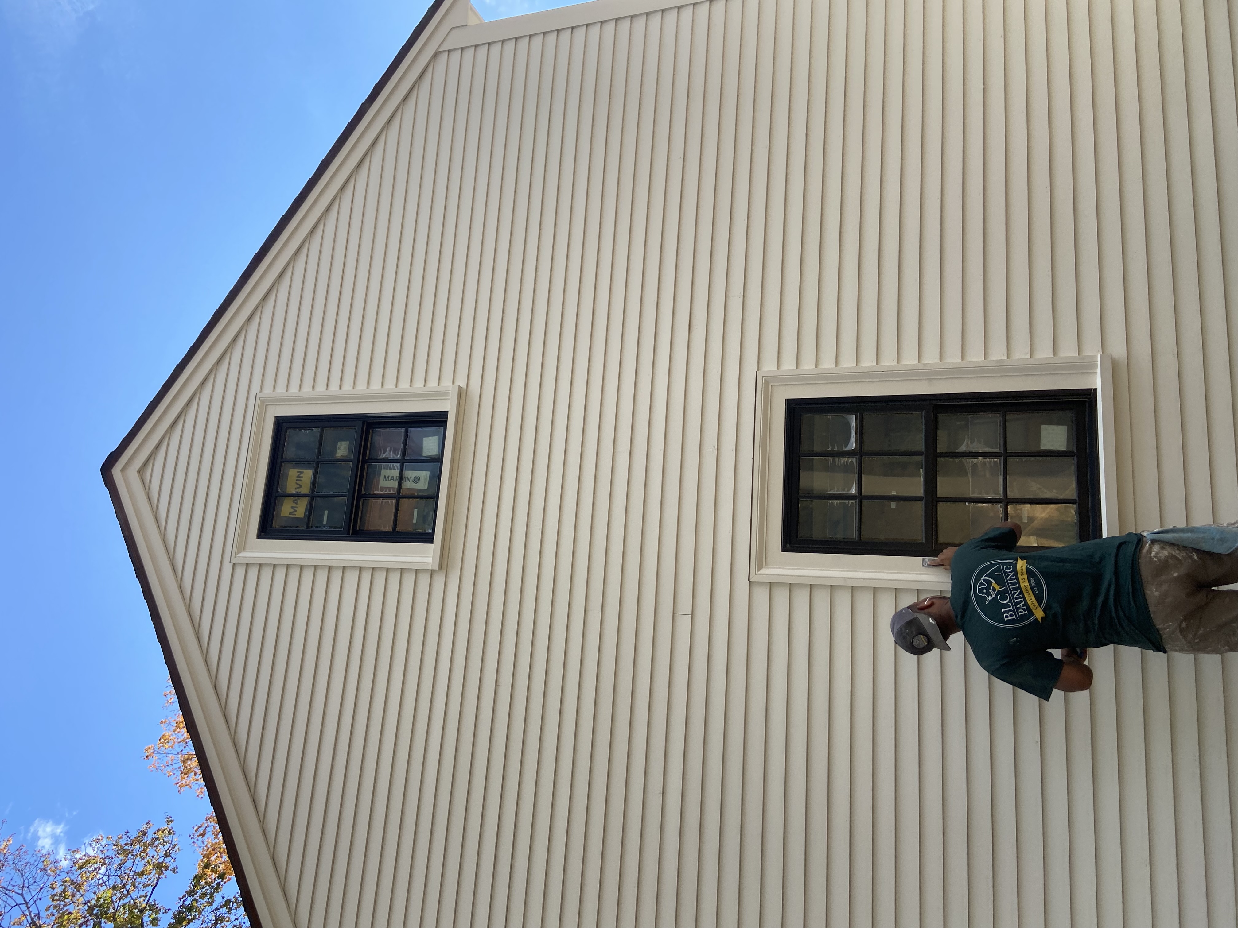 BLC Painting crew member prepping a house exterior before painting