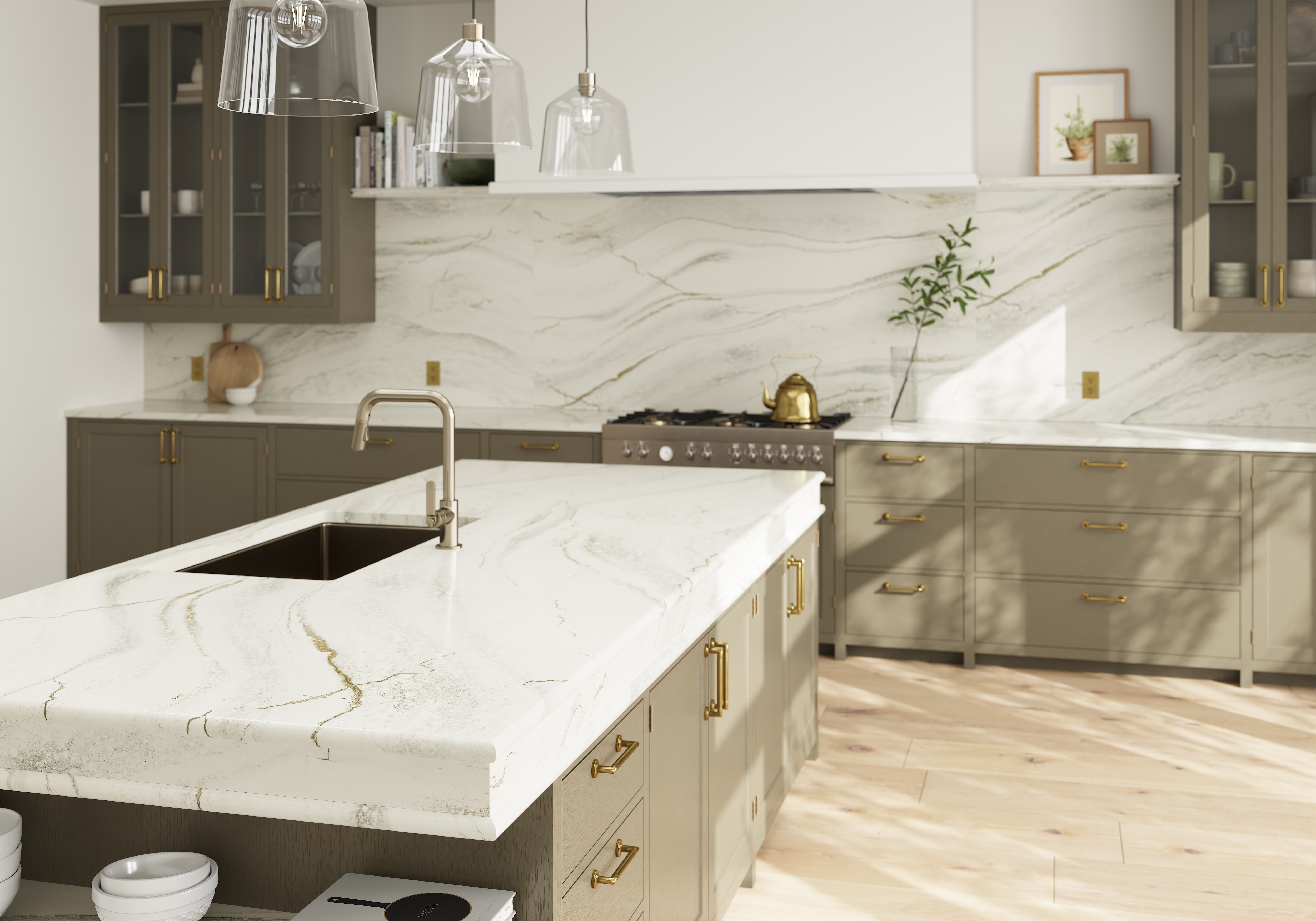Taupe kitchen cabinetry with brass handles, glass-front upper cabinets, and a white veined island countertop