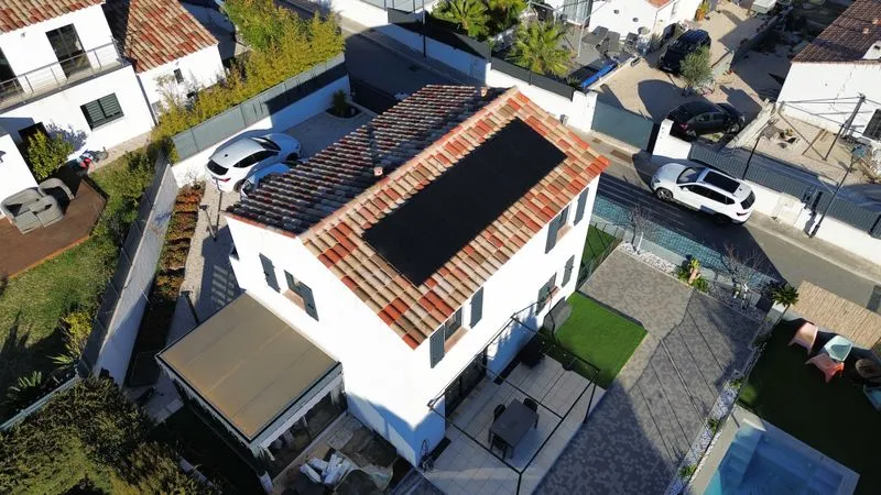 Vue aérienne de panneaux photovoltaïques sur une toiture en tuiles.