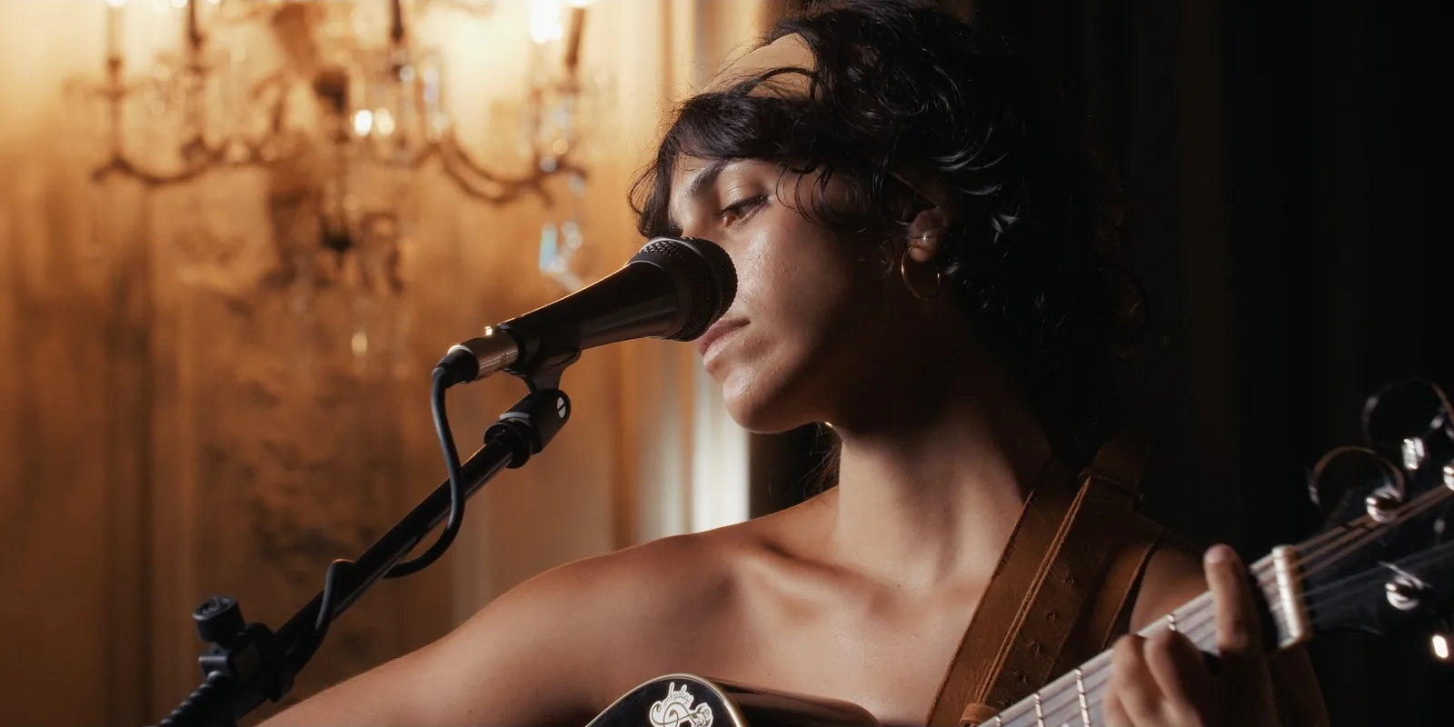 Anjelique canta al microfono: primo piano della performance Siente