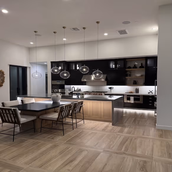 A clean, modern kitchen with a wood island and pendant lights, from the Spotless Society gallery