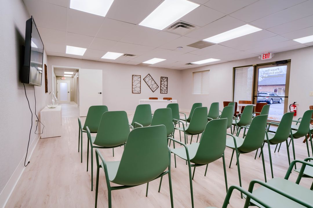 Rows of green chairs in a bright group meeting room at Dove Recovery