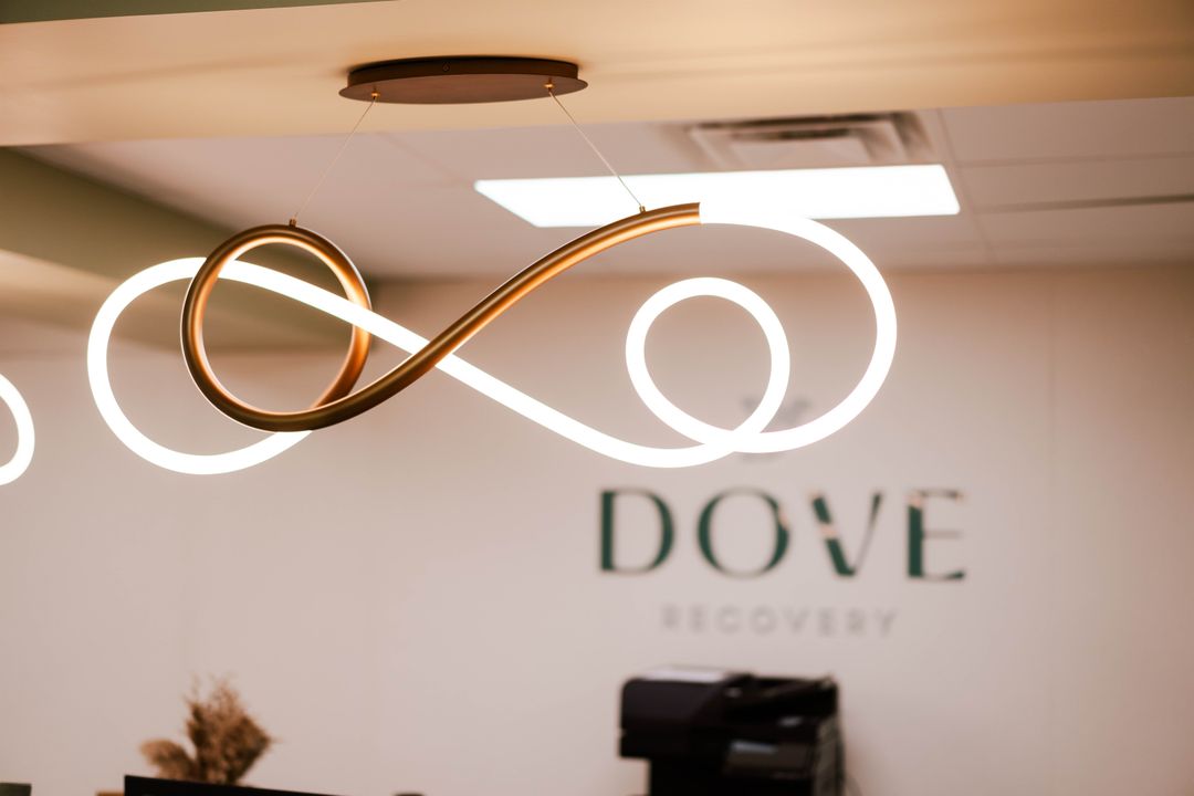 Sculptural pendant lighting in front of the Dove Recovery reception sign
