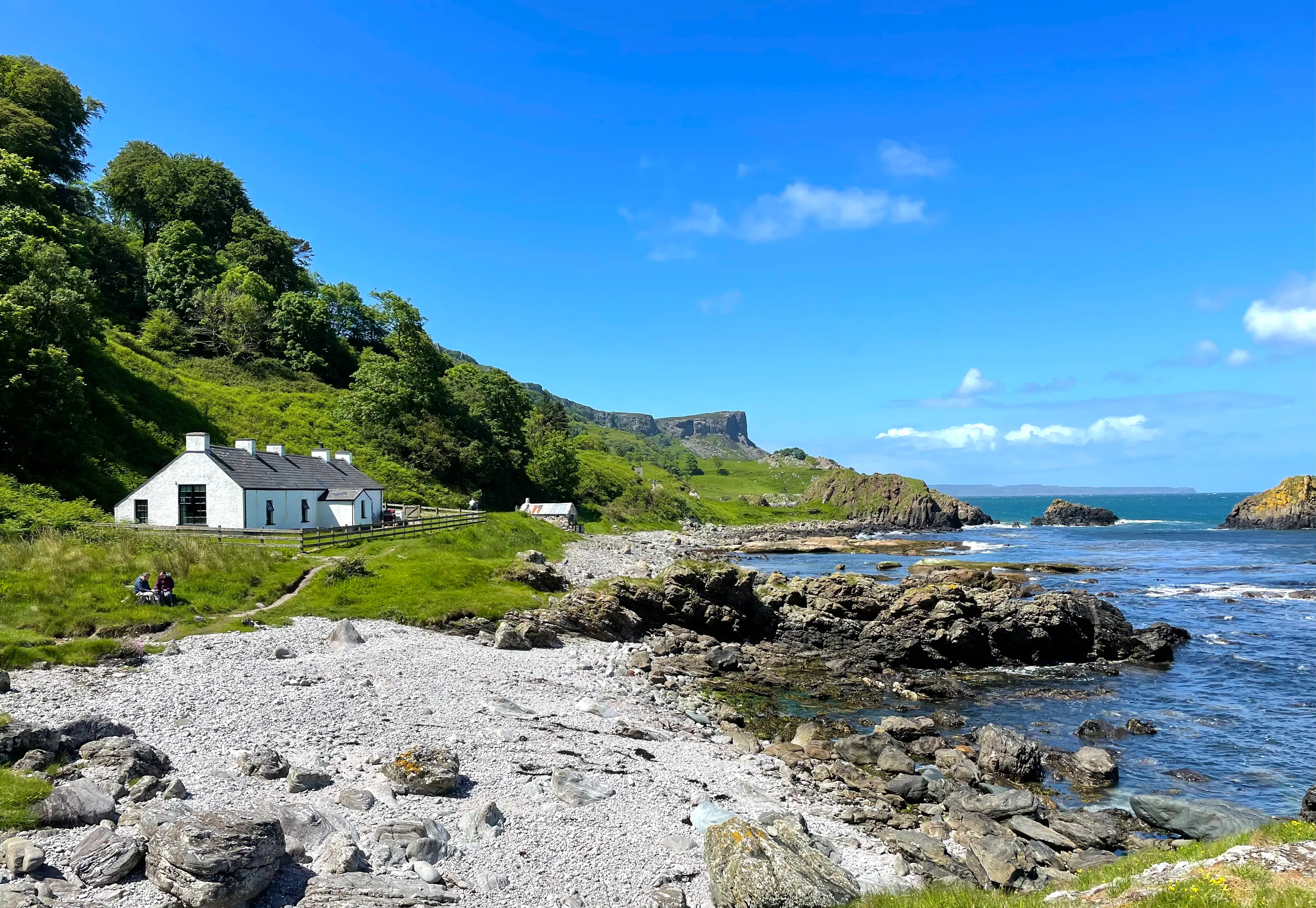 White coastal cottage beside a rocky bay
