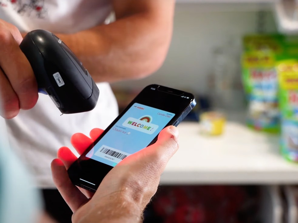 Une vendeuse scanne la carte de fidélité Wallet d un client sur son iPhone à la caisse chez Haribo