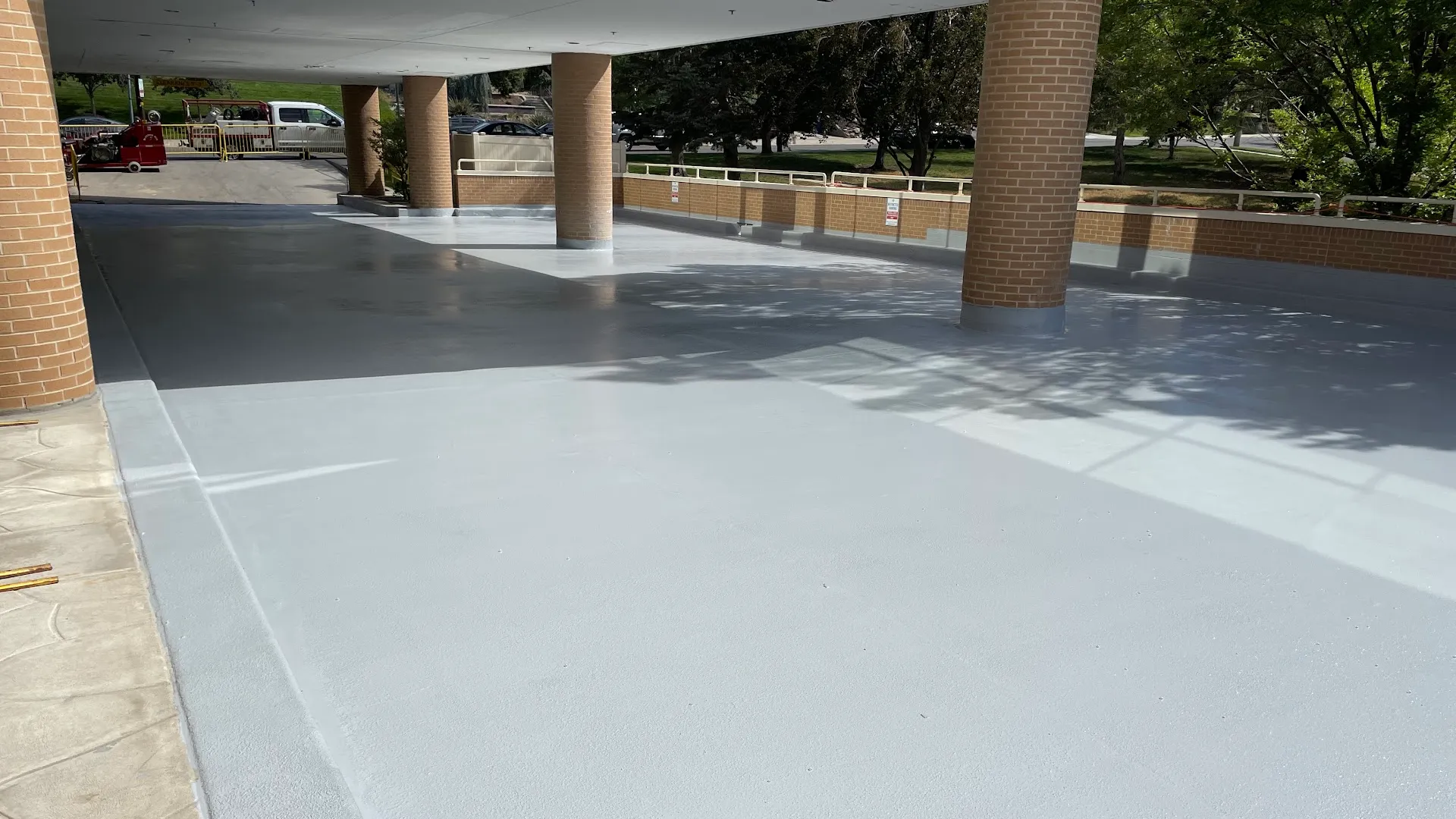 After: the same parking garage deck, repaired and finished with a gray protective coating.