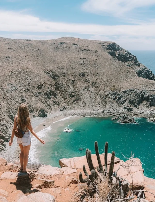 Viajera observando una playa y el paisaje desértico de Todos Santos