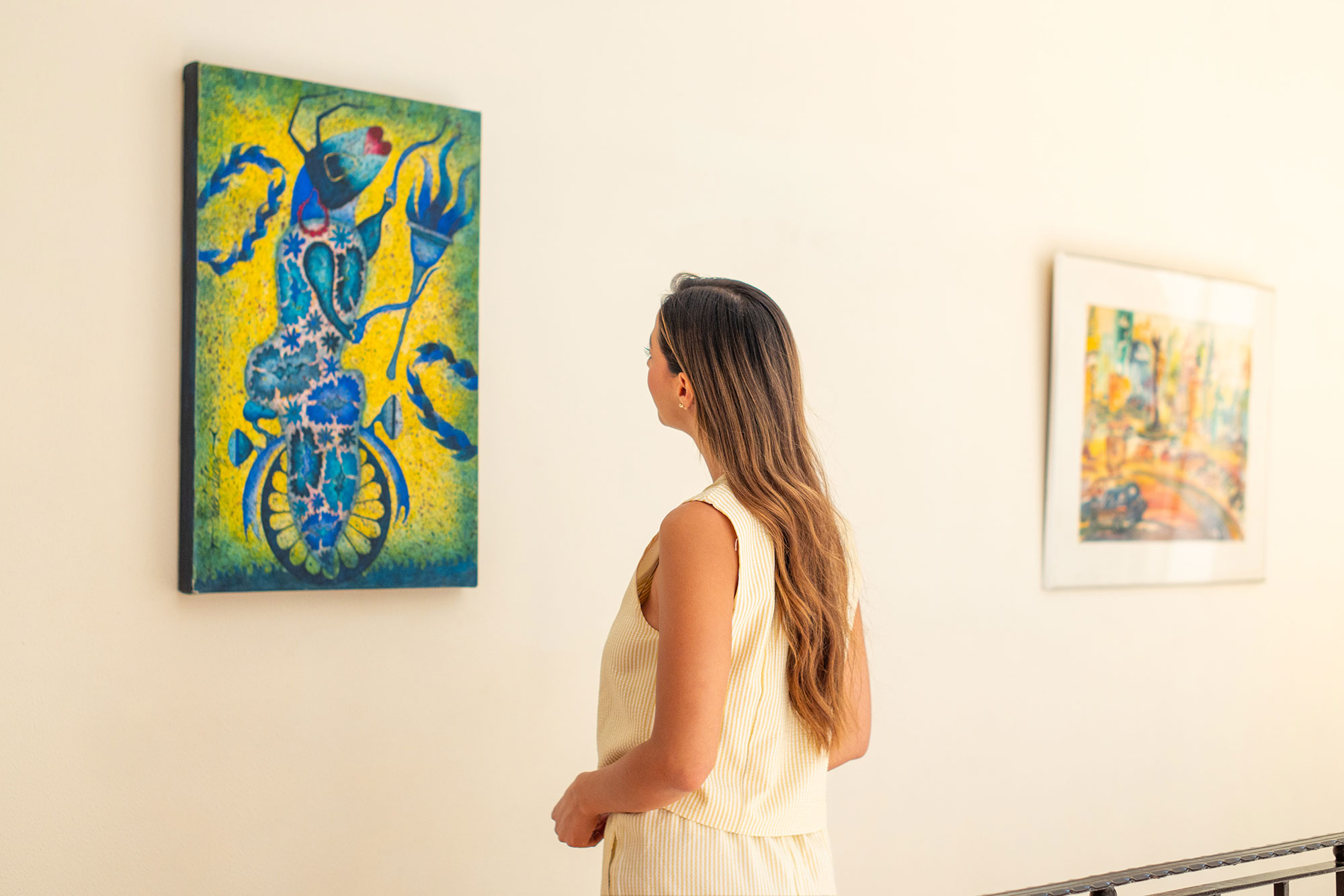 Visitante contemplando una pintura en un espacio de arte de Guaycura