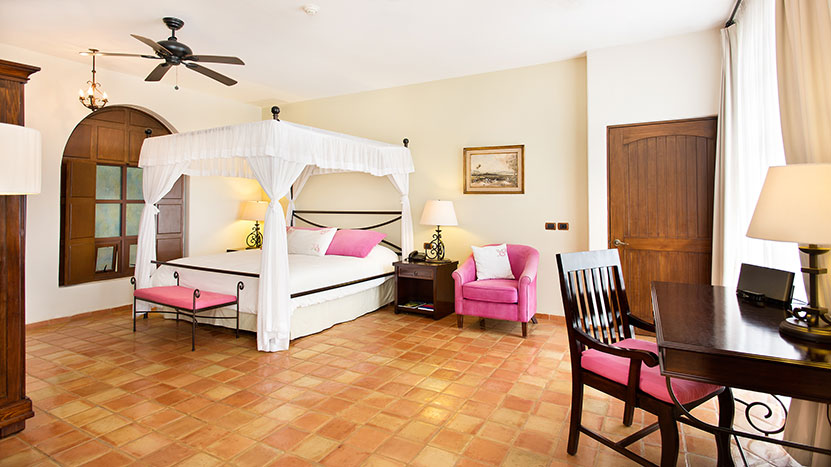 Hotel Guaycura room with a canopy bed and pink accents