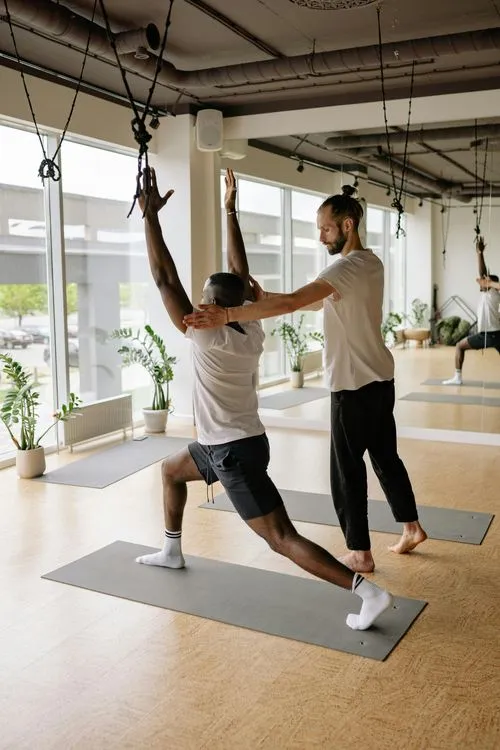Entrenador personal corrigiendo la postura de un principiante en el gimnasio