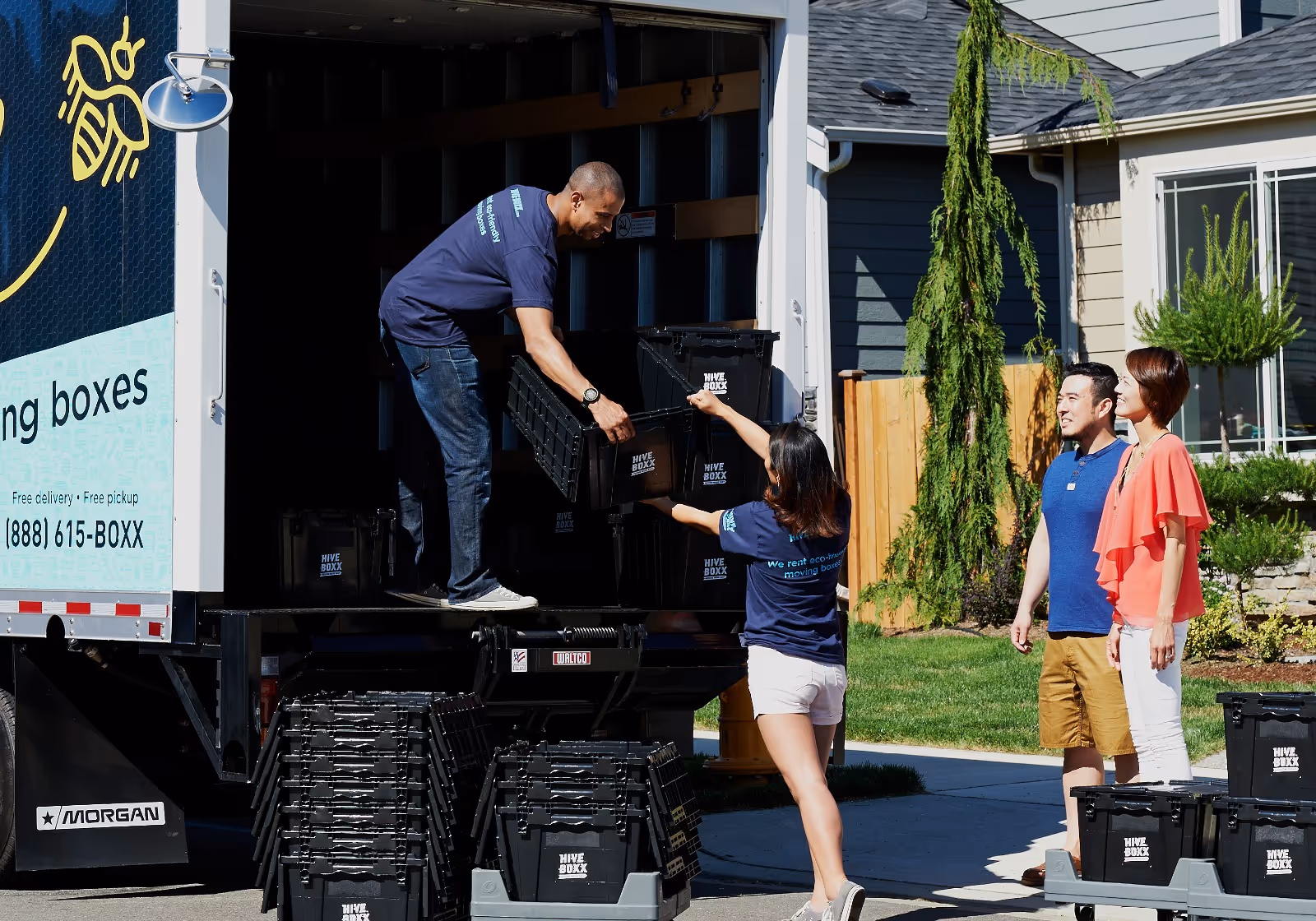 People handing over reusable HiveBoxx bins outside a home.