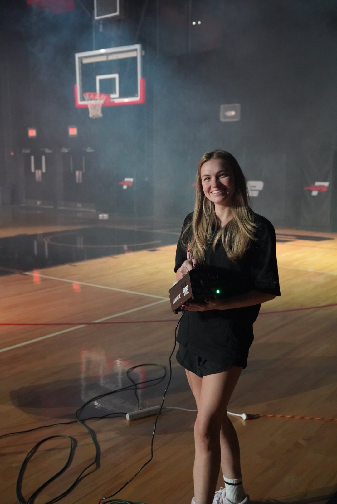 A crew member preparing effects on the basketball court