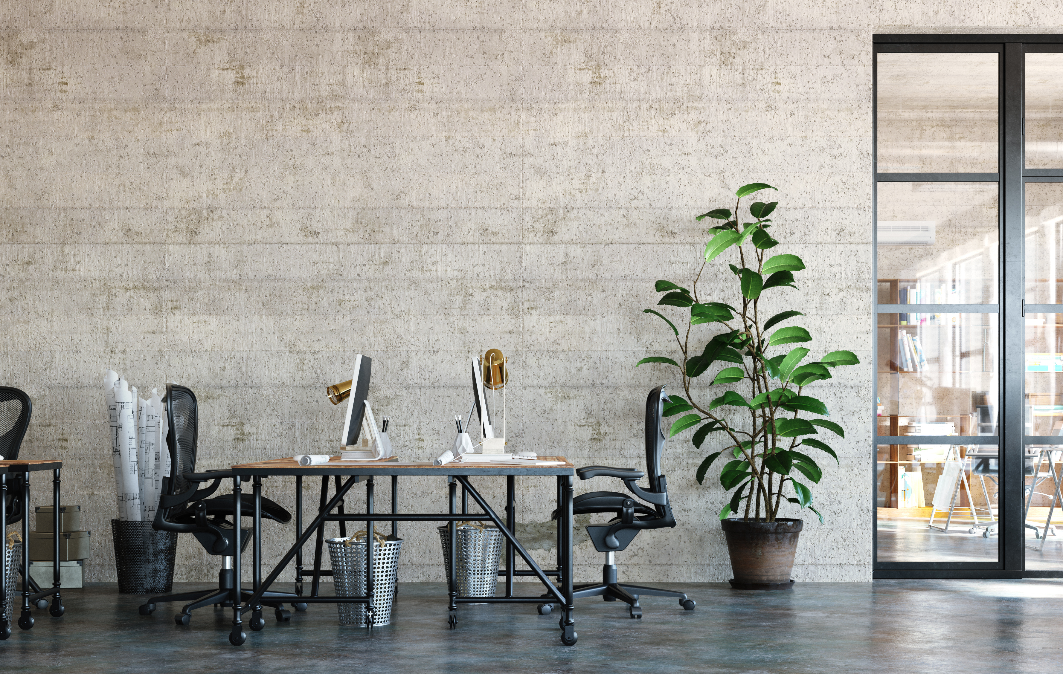 Smiling man sitting outdoors, holding a laptop, surrounded by lush green plants in a modern workspace.