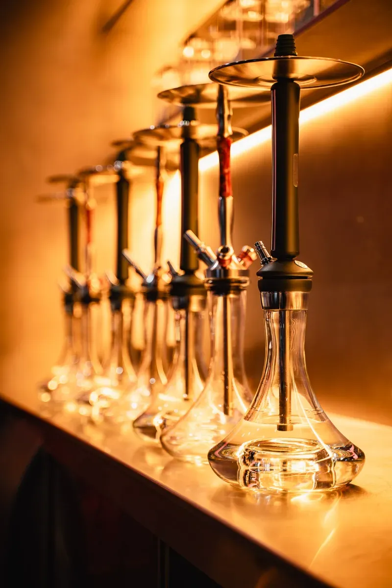 Hookah collection arranged beneath warm lighting at Myata Platinum