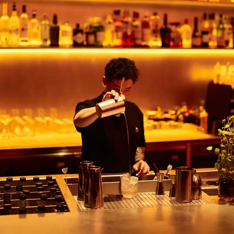 Bartender preparing a cocktail at the warmly lit Myata Platinum bar