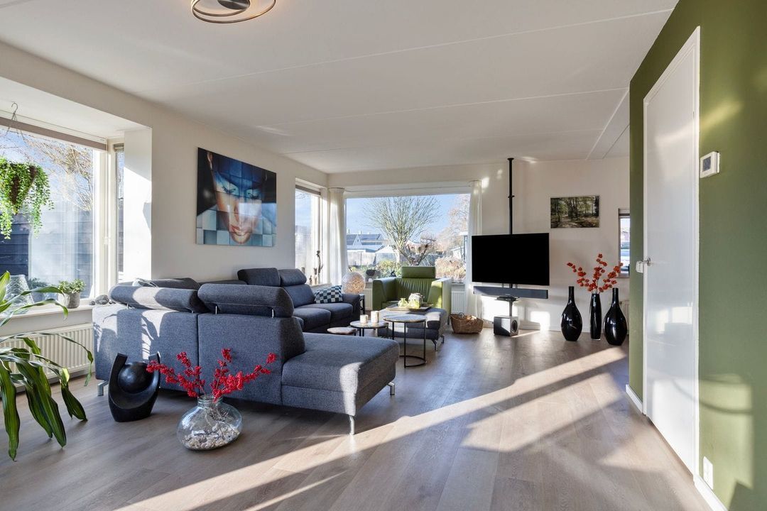 Voor: woonkamer met donkergroene wand en deur
