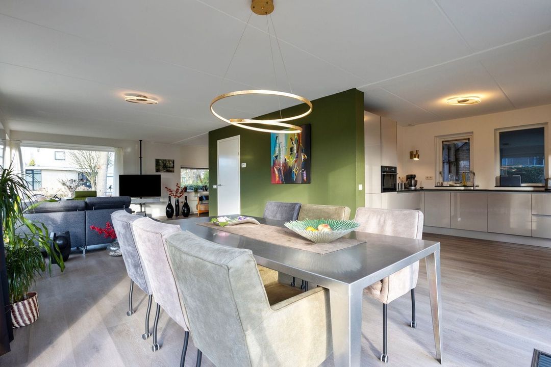 Voor: eethoek en keuken met donkergroene middenwand