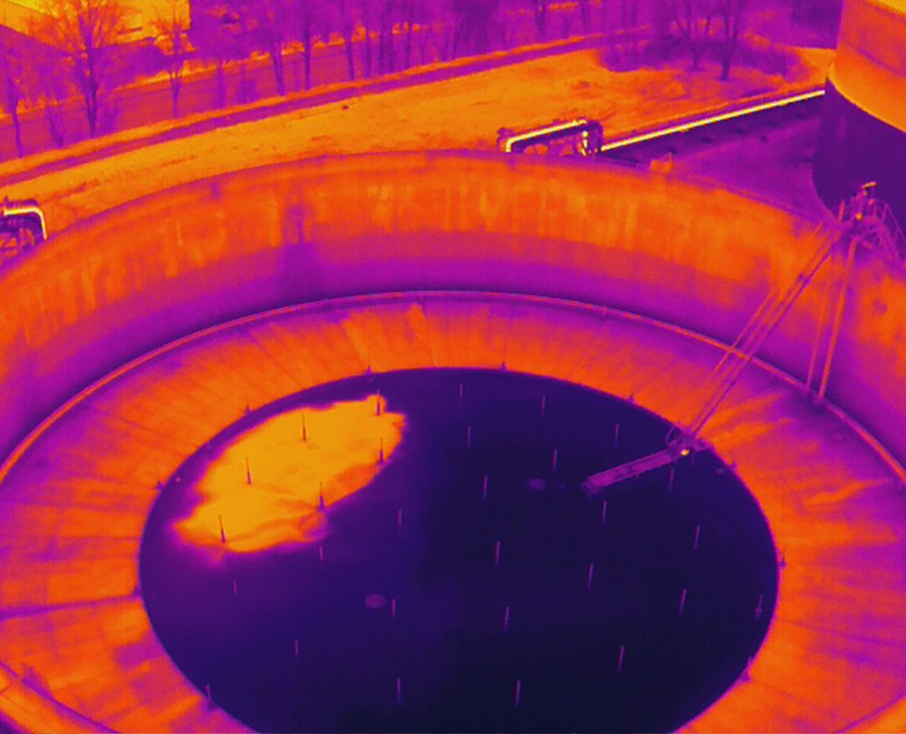 Thermal version of the same frame, showing standing water on the tank roof.