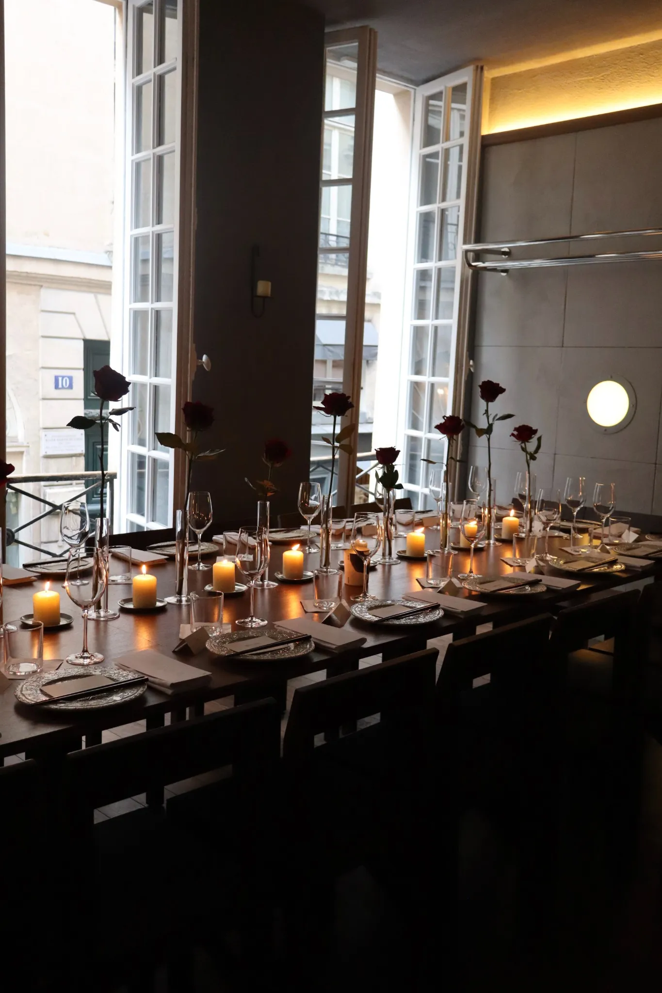 Table privative d’Orson dressée avec des bougies et des fleurs près des fenêtres