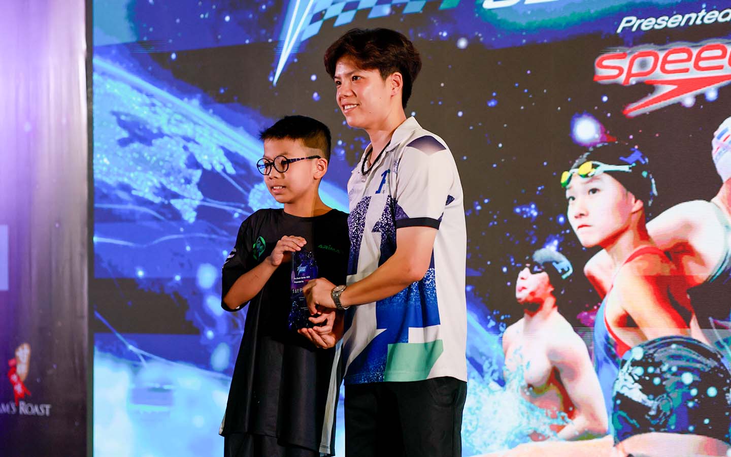 Coach Noey presenting an award to a young swimmer at the F1RST Pro Swim Series